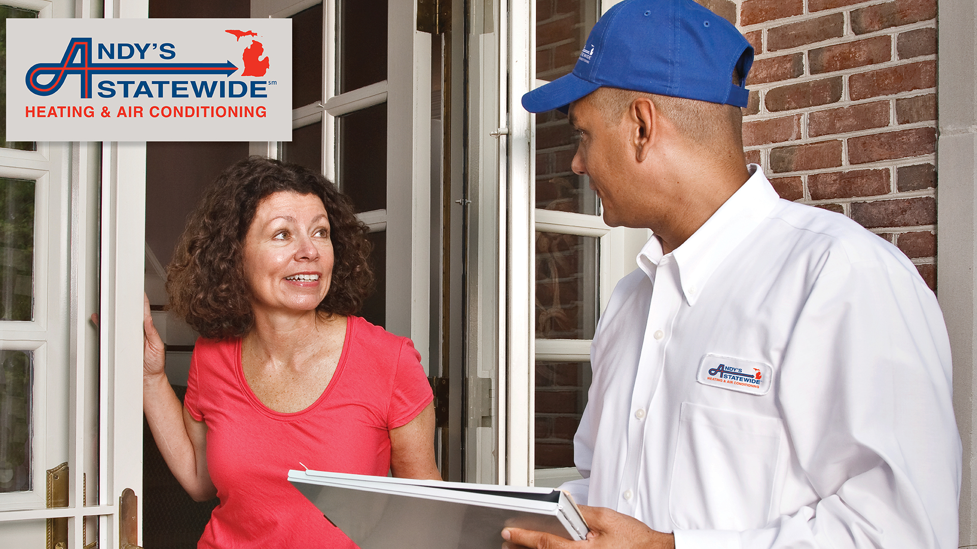 Andy's Statewide heating and cooling technician at Troy, MI, home, speaking with a woman on her doorstep. 