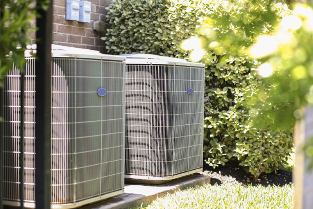  Photo of a central air conditioning unit outside a home on a sunny day.