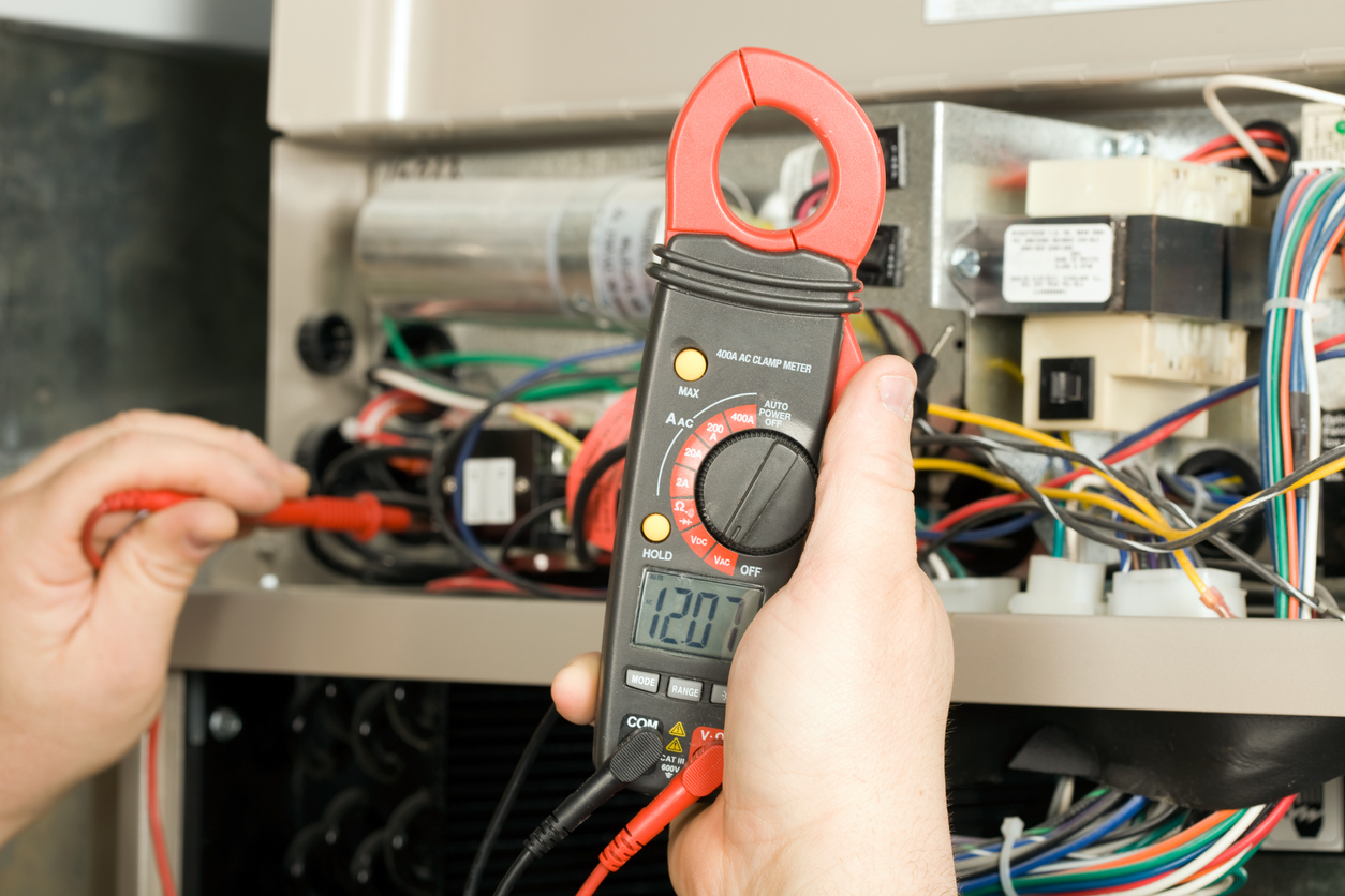  HVAC technician checks voltage on an HVAC system in Oxford, MI.